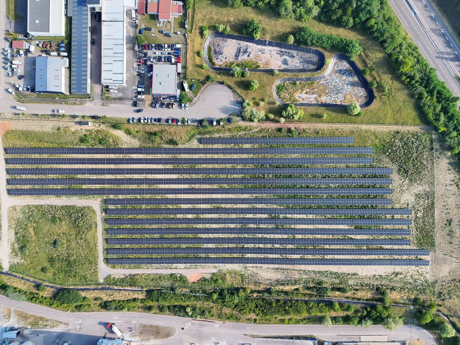 Vue aérienne verticale d'une centrale photovoltaïque et de bâtiments industriels